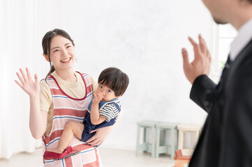 保育園に朝赤ちゃんを送ってバイバイするパパさん　のズームと見送る保育士さんのズーム1　真ん中にコピースペースあり