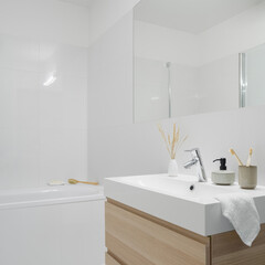 Simple bathroom with washbasin with wooden cabinet