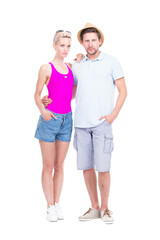 Vertical full length studio portrait of stylish young man and woman wearing summer outfits standing together embracing each other, white background