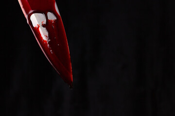 A bloody knife on a black background. The concept of murder, crime.