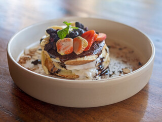 Pancakes with berries and fruits on a white plate