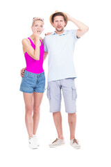 Vertical full length studio portrait of young adult Caucasian man and woman astonished at something, white background