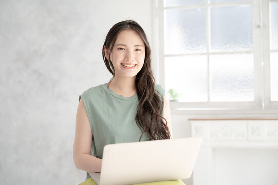 パソコンで仕事をするカメラ目線の美しい日本人女性1　コピースペースあり 