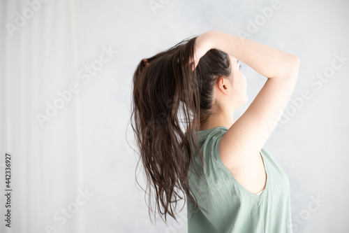 ヘアケアなどに使えそうな髪の毛をかきあげる後ろ姿の美しい女性2 左あきコピースペース Wall Mural Kapinon