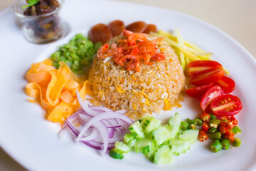 Rice Mixed with Shrimp paste (Khao Kluk Kapi) is a Thai traditional food was served with shallot, cucumber, mango, caramelized pork, dried shrimp, cropped sausage, omelette, cilli and yardlong beans.