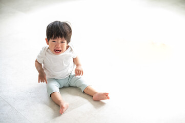 大号泣するアジア人(日本人)の赤ちゃんの俯瞰2　左にコピースペースあり