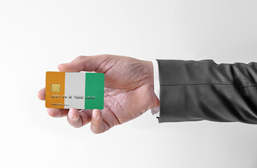 Bank credit plastic card with flag of Cote d'lvoire holding man in elegant suit - 442338138
