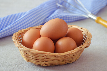 Raw chicken eggs in wicker basket