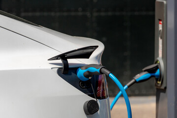 Green energy concept, Selective focus of power supply connect to electric vehicle for charging battery, Charging an electric car in public station by the street in Amsterdam, Netherlands.