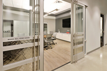 Sliding glass door leading to modern conference room in  office business building