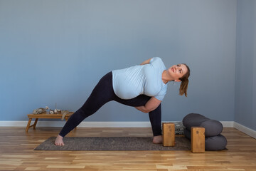 woman practicing yoga, doing lunge exercise, Side Angle Pose, Parsvakonasana,