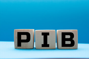 Word PIB. Wooden small cubes with letters isolated on blue background with copy space available. Business Concept image.