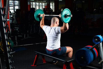 Male athlete lifts the barbell