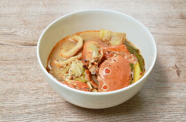 boiled flower crab and shrimp couple squid with do;;y fish in Thai spicy soup or seafood tom yum on bowl