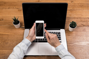 Cropped image of a woman holding a smartphone to receive a message confirming the transaction on a...