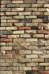 Untreated brick wall, unevenly laid outer wall of the building. Brick wall background.