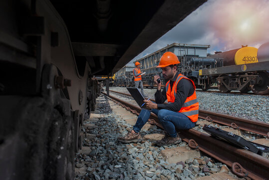 Worker Sitting On Rail With Checking Folder In Hand  On Worker  Background.  Worker On Rail Way.