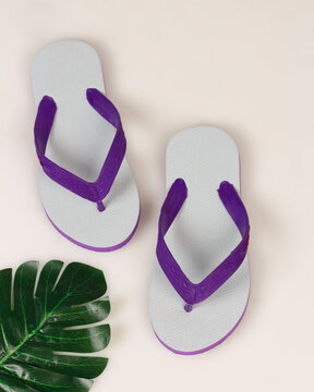 Swallow sandals white mixed with purple on a bright background. Swallow sandals are very comfortable to use for everyday footwear. Lightweight and also flexible. Free space for your ad. Shoe mockup.