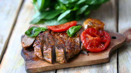 Appetizing juicy steak sliced on a wooden board.