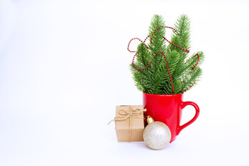 Christmas composition with red mug, tree decorations and gift isolated on white background. Copy space. Blank for a greeting card.