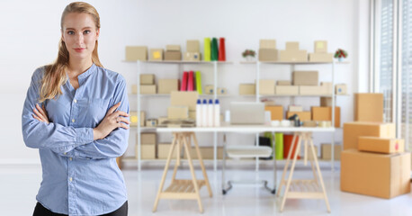 Fototapeta premium Smart and young caucasian businesswoman entrepreneur self confident standing and working at home with start up small business or online SME freelance and box packaging background