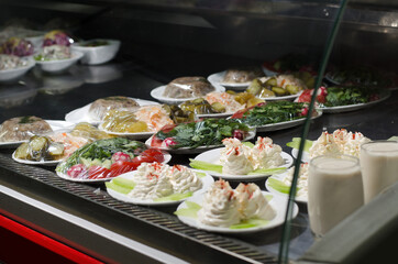 Showcase refrigerator with salads of chopped fresh vegetables and pickles