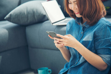 Smiling face asian woman holding smartphone with E-commerce Shopping online website Reading Online Article, Blog, vlog. Young Woman hands holding phone technology lifestyle. Woman using smart phone.