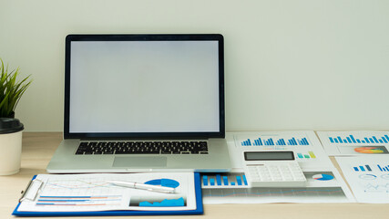 laptop computer and graphing documents with calculator on business man's desk