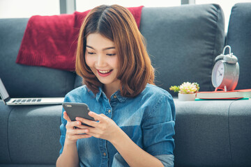 Smiling face asian woman holding smartphone with E-commerce Shopping online website Reading Online Article, Blog, vlog. Young Woman hands holding phone technology lifestyle. Woman using smart phone.