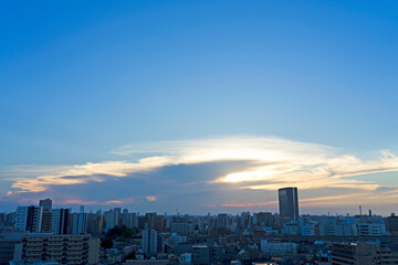 Fototapeta premium 雲間から見える夕日と街