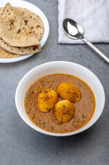 Fried egg curry or Anda Masala served in a bowl with chapati 