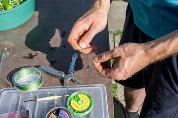 Hobbies and active recreation. A man is going fishing and makes a snap for a fishing rod.