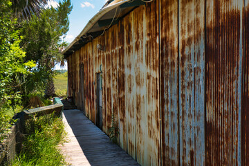 An old rusty metal shed beside a salt marsh in the low country of Georgia, USA.