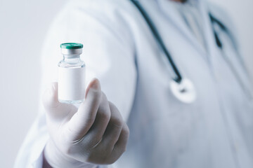 Fototapeta premium Doctor holding single bottle vial of vaccine for children or adults. Concept fight against virus. Medical health care concept vaccination hypodermic injection treatment vintage background.