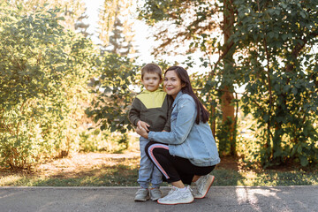 portrait of a happy young mother with a young son in the park. the concept of happy motherhood