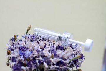 syringe in flowers. Cosmetological procedures. Injections, injections. Diseases, treatment, medicine, vaccine.
