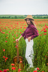 spring countryside. lady wear checkered shirt and hat in flower field. country music singer.