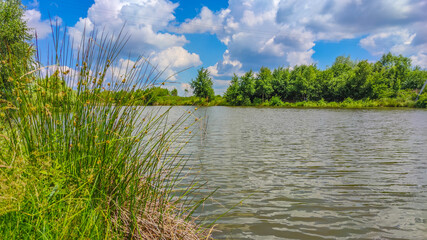 Landscape with a lake and clouds in the sky in the summer season