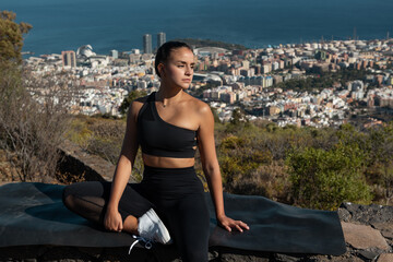 Fototapeta na wymiar photograph of a girl in black sportswear practicing yoga and sports outdoors with beautiful views behind her