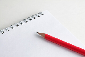 pink pencil lies on a white sheet of notepad, school topics