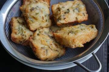 The flour fried tempeh is drained so that the remaining cooking oil is reduced              