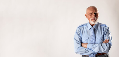 Old man looking at the camera on gray background with copy space.