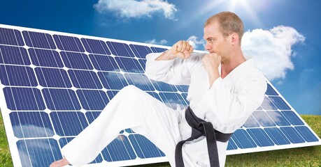 Digital composite image of caucasian male marital artist with black belt against solar panels