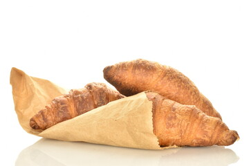 Three fragrant croissants with chocolate filling with a bag of craft paper, close-up, isolated on white.