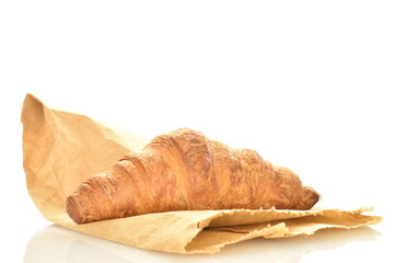 One fragrant croissant with chocolate filling on a bag of craft paper, close-up, isolated on white.