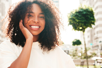 Beautiful black woman with afro curls hairstyle.Smiling hipster model in white t-shirt. Sexy...