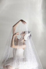 Young graceful balerina in image of white swan in art performance isolated on gray white background. © Lustre Art Group 