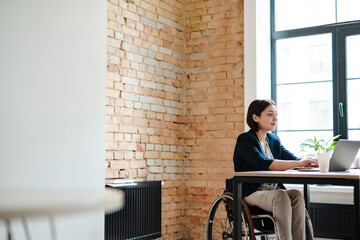 Young disabled business woman in wheelchair working