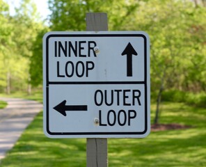 A close view of the black and white sign in the park.