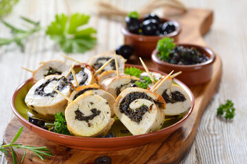 Leckere Scheiben aus Hähnchenroulade mit schwarzen Oliven und Petersilie als Fingerfood und Tapas - Slices of chicken roll stuffed with black olives and parsley and served as finger food or tapas